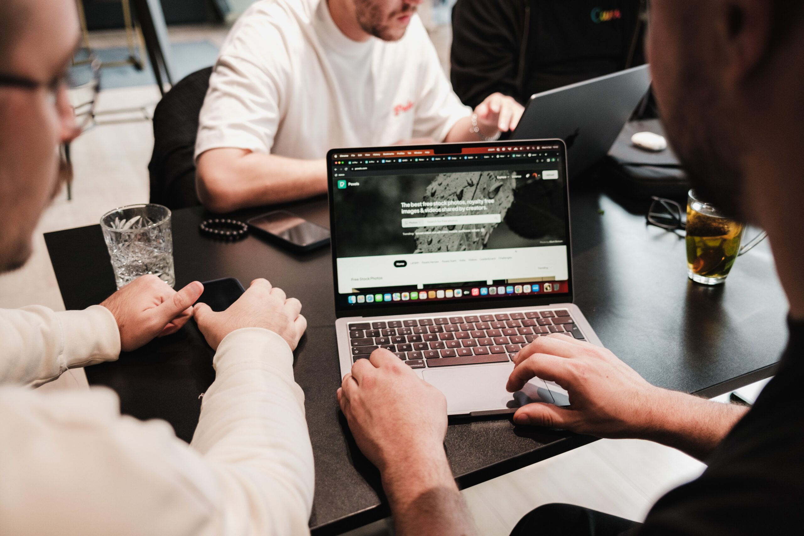 Digital marketing team discussing a campaign together around a laptop in a meeting